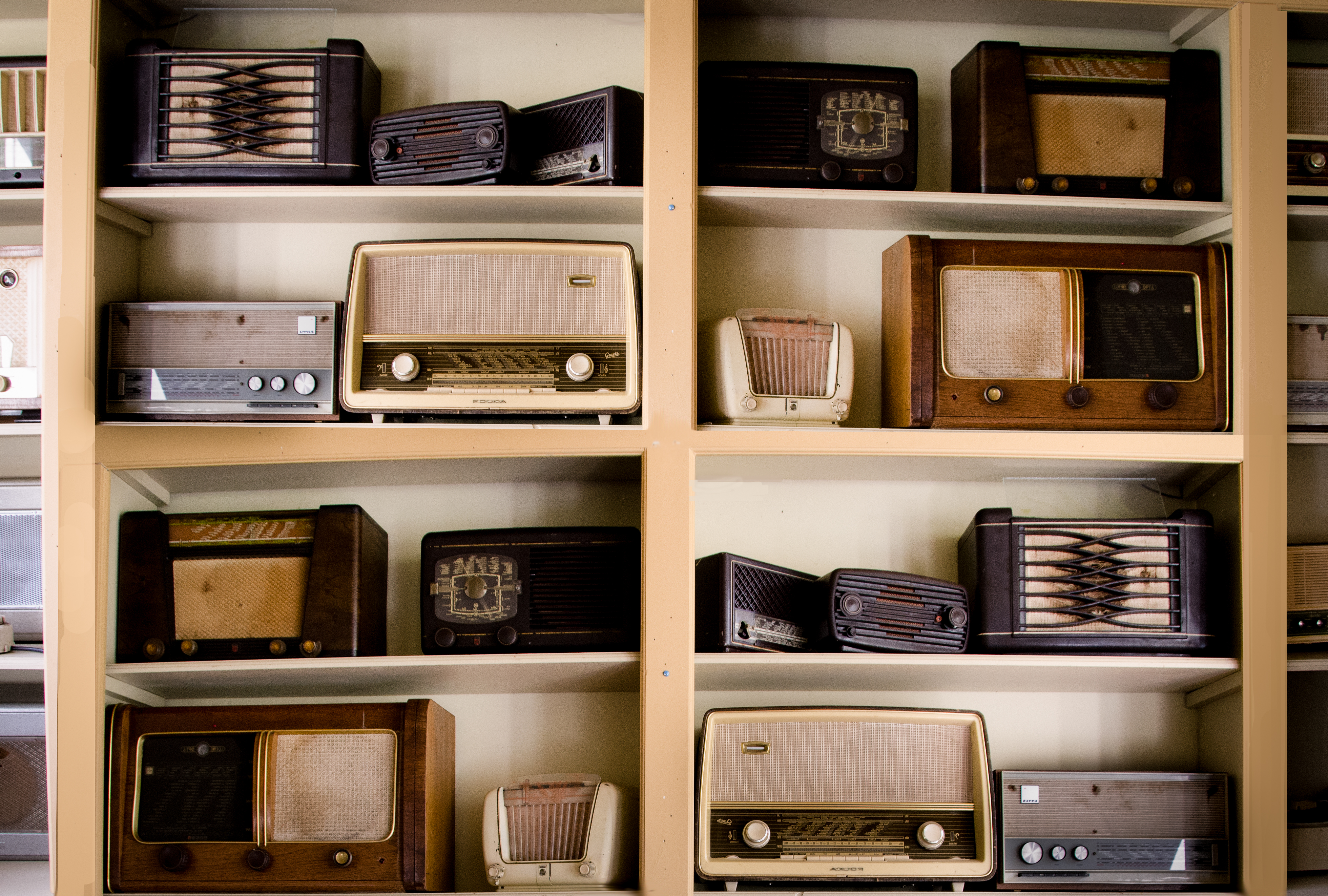 A photo of a shelving set with lots of old fashioned radios